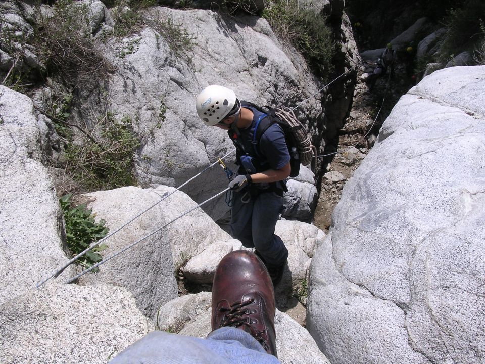 Rock climbing scene with a person rappelling down a rocky canyon