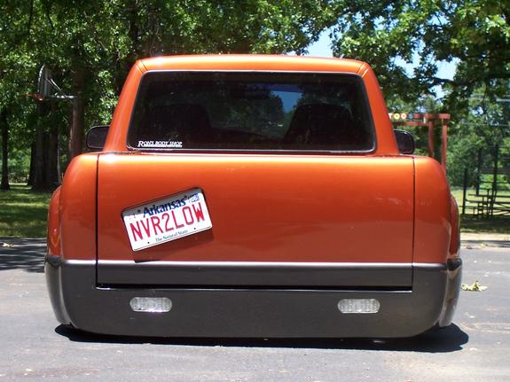 Orange pickup truck rear view, lowered, with Arkansas license plate NVR2LOW