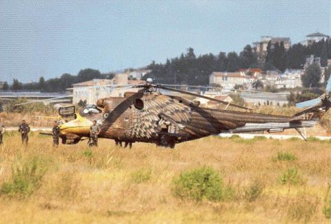 1968 Ford Mustang - A military helicopter with distinctive eagle wing camouflage is parked in a field, with a smaller yellow aircraft nearby.