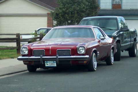 1972 Ford Ranchero - A red coupe with a Colorado license plate is parked on a residential street.