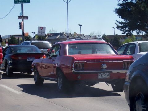 1972 Ford Ranchero - A red 1967 Ford Mustang coupe is viewed from behind while stopped in traffic.