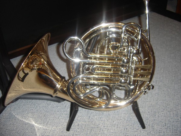 Brass French horn on a stand