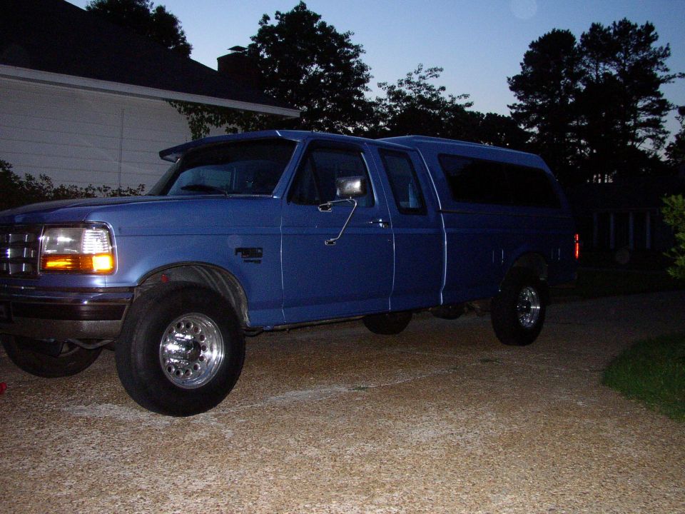 1995 Ford F-150 pickup truck with a blue camper shell, side view