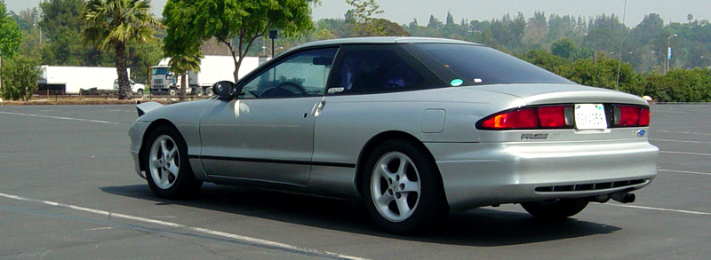Silver Ford Probe GT rear 3/4 view in a parking lot with trailers behind