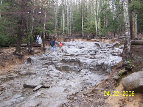 1995 Ford Bronco - A group of people navigate a challenging rocky terrain in a wooded area, captured on April 22, 2006.