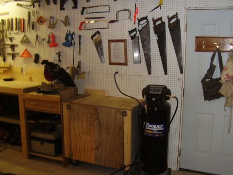 1990 Ford Bronco - A workshop scene a pegboard wall adorned with tools, a workbench, and a Kobalt air compressor.