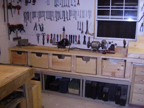 1990 Ford Bronco - A workshop scene a workbench filled with tools and storage drawers, organized on a pegboard wall.