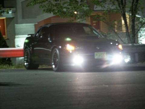 2001 Mercury Grand Marquis - A black convertible sports car is parked at night with its headlights illuminated.