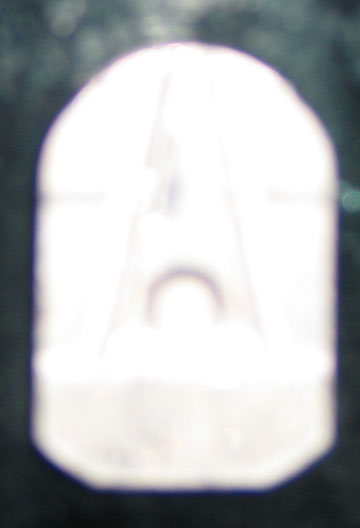 1994 Ford Bronco - A white plastic part is shown, with a faint 'A' shape visible within its translucent material.