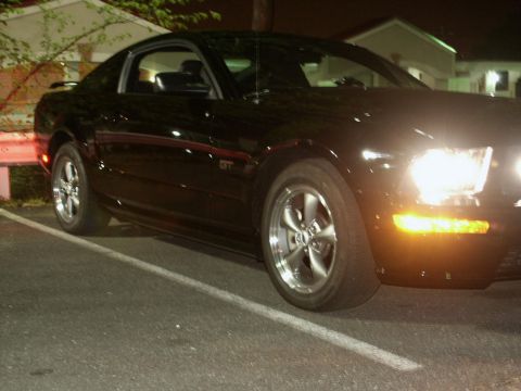 2001 Mercury Grand Marquis - A black coupe with a GT badge is parked at night, showing its front wheel and headlight.