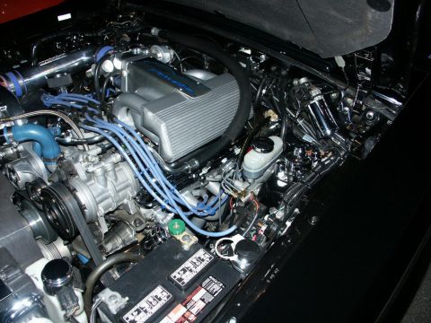 2001 Mercury Grand Marquis - A detailed view of a modified engine bay, chrome components and vibrant blue spark plug wires.