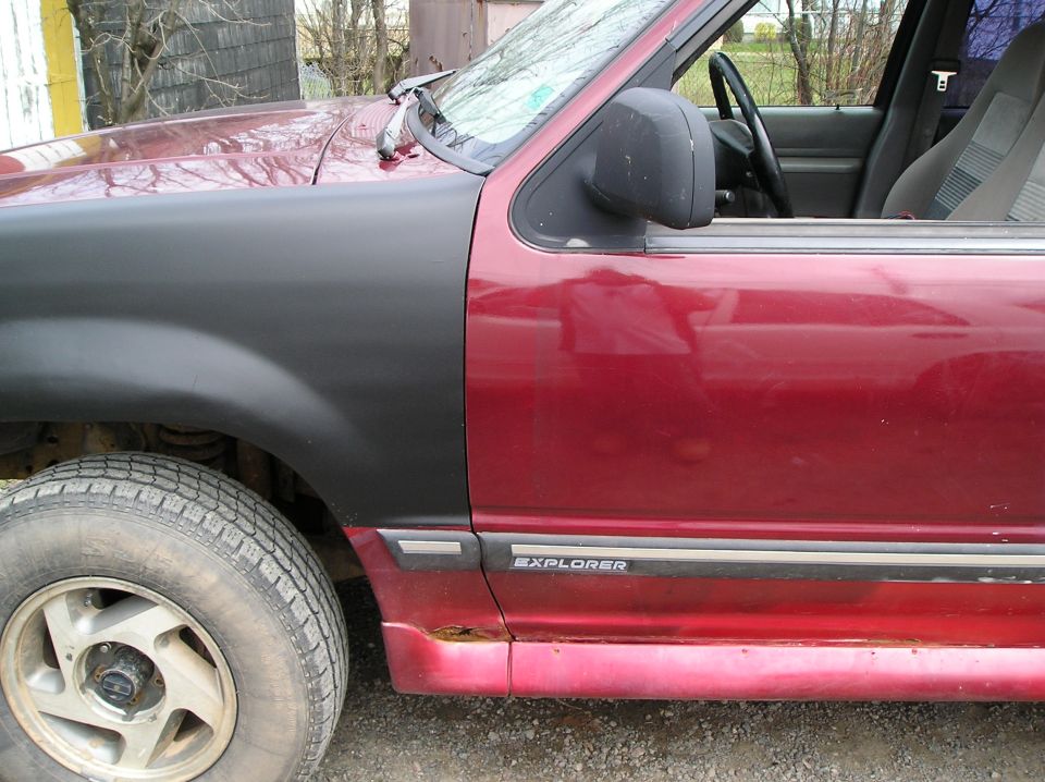 Red SUV side view with black fender and Explorer badge. 1991 Ford Explorer