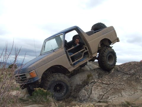 1989 Ford Bronco - This heavily modified Ford Bronco is tackling a challenging rock crawling course.