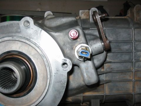 1995 Ford Bronco - This is a close-up view of a vehicle's transfer case, showing mechanical components and electrical connectors.