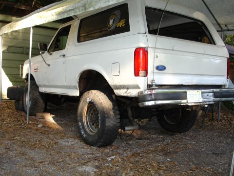 1989 Ford Bronco - This 1989 Ford Bronco is shown from the rear, lifted with large tires and parked under a canopy.