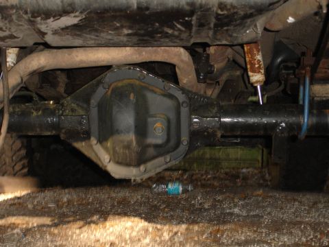 1989 Ford Bronco - Underside view of a vehicle's rear axle assembly, showing the differential housing and suspension components.