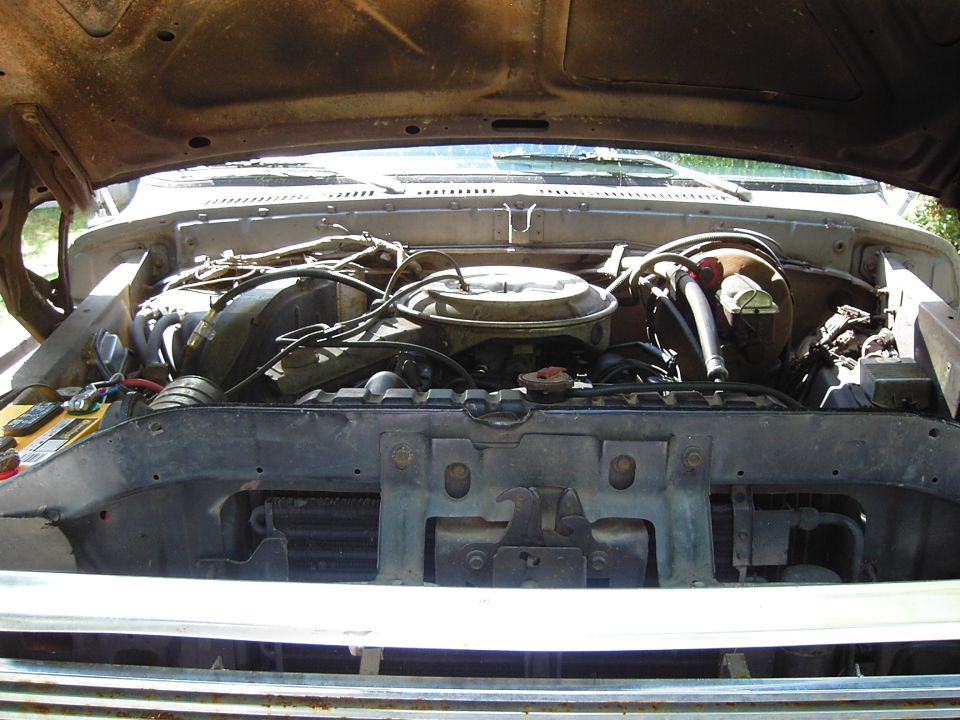 Engine bay with V8 engine and radiator. Supermotors.net logo visible