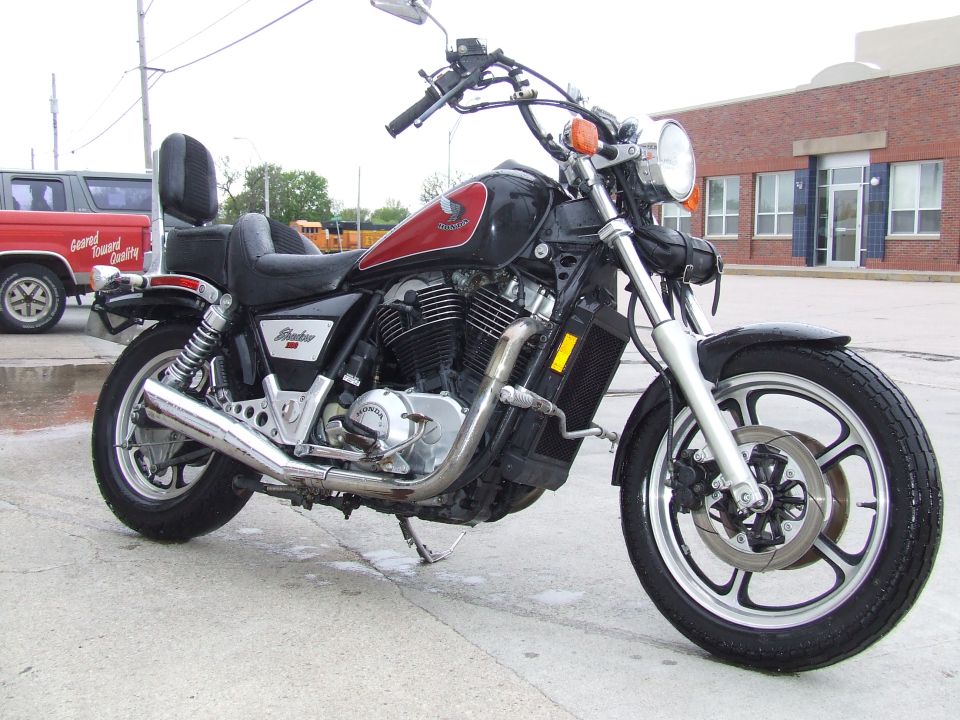 Motorcycle parked next to a red pickup truck