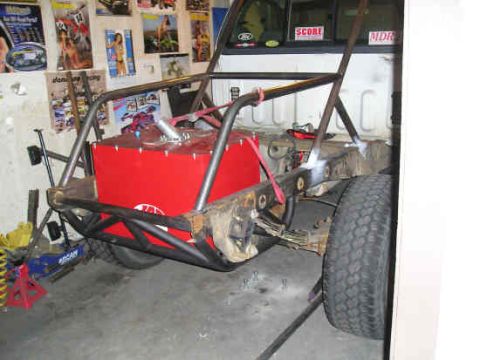 2002 Ford F-150 - Custom off-road truck frame modification with a large red fuel cell and rear suspension components.