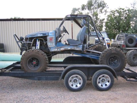 1987 Suzuki Samurai - This heavily modified buggy, possibly a custom build, is seen on a trailer with another truck in the background.
