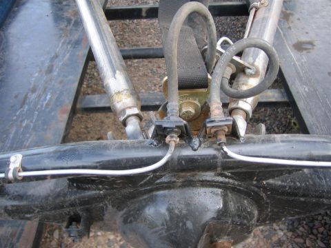 1987 Suzuki Samurai - Detail of a vehicle's rear axle assembly, showing brake lines and suspension components.