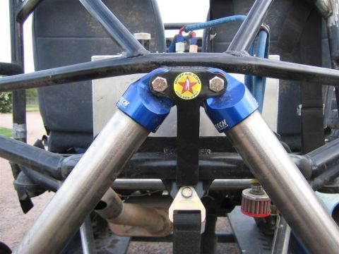 1987 Suzuki Samurai - Close-up of suspension and roll cage components on a modified off-road vehicle.