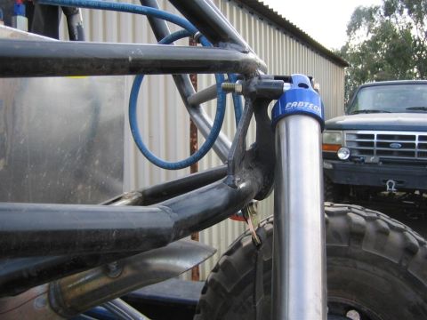 1987 Suzuki Samurai - A custom buggy's suspension system is shown, with a Ford Bronco visible behind it.