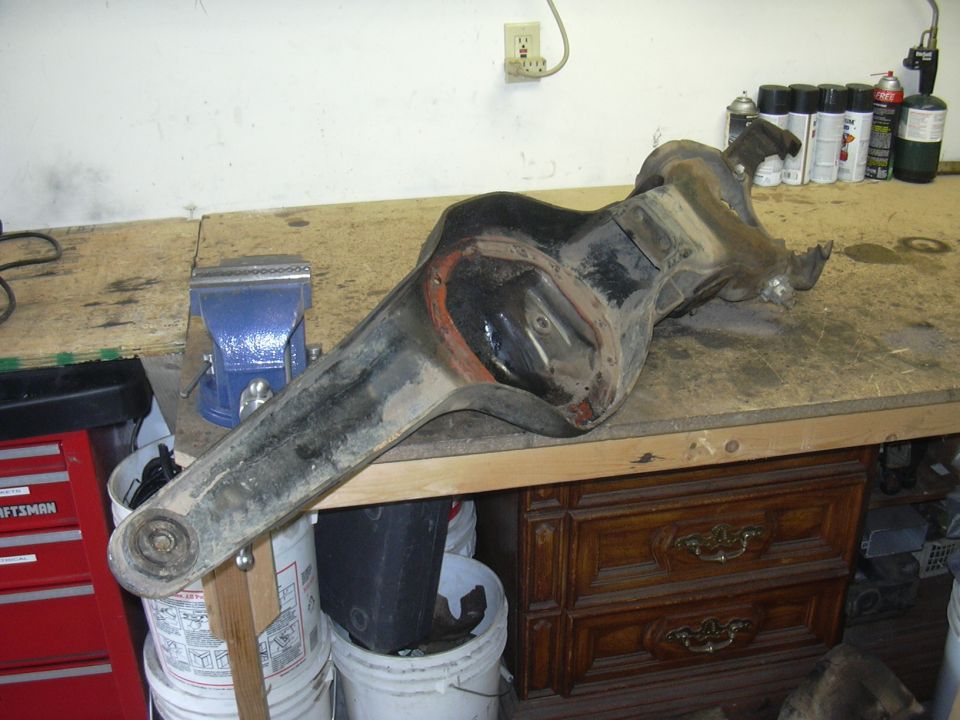 Differential axle housing on workbench with vise