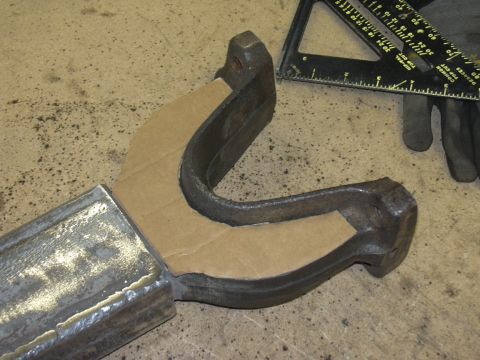 1991 Ford Bronco - A metal component is being worked on, with a cardboard template placed for reference. A speed square and gloves are nearby.