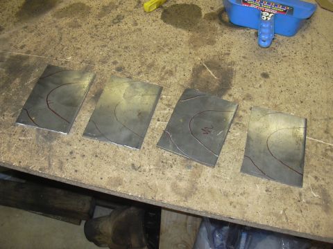 1991 Ford Bronco - Four metal plates with scribe lines are laid out on a workbench, possibly for a fabrication project.