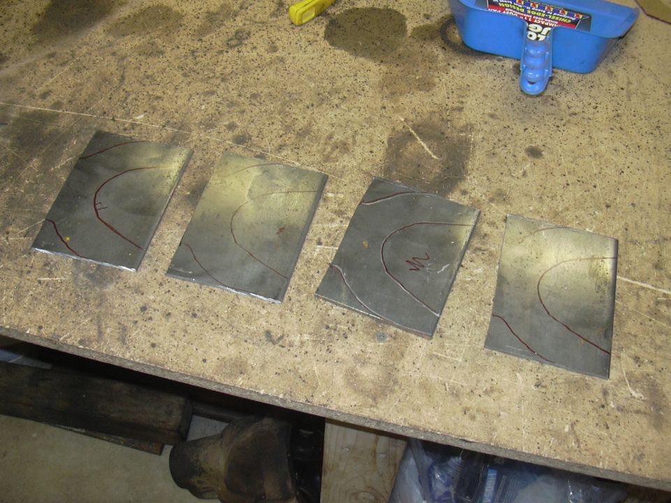 Four rectangular metal plates with red scribe lines on a workbench