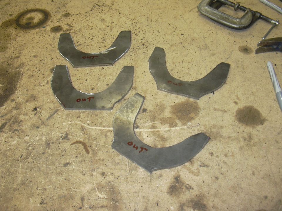 Four metal brackets with 'OUT' written on them