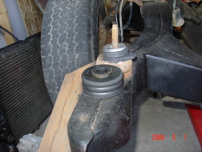 1972 Ford Ranchero - Vehicle suspension component with rubber bushing and metal bracket. Background shows tire and radiator.