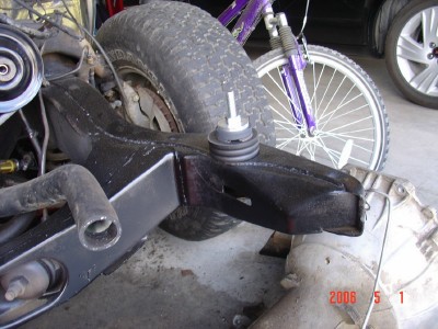 1972 Ford Ranchero - A vehicle's frame component is shown with a bicycle and another vehicle wheel in the background.