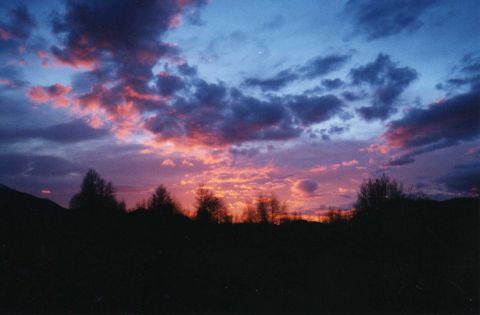 2001 Ford Taurus - The sky displays a vibrant sunset with colorful clouds above a dark, silhouetted landscape.