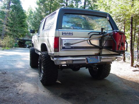 1986 Ford Bronco - This 1986 Ford Bronco features a lifted suspension and a rear-mounted jerry can, suggesting it's prepared for off-road adventures.