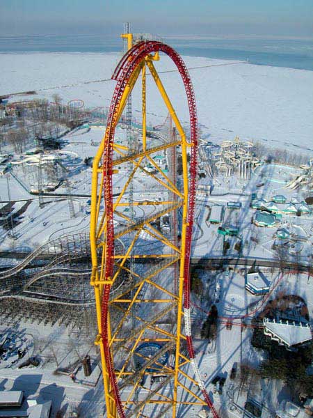 1968 Ford Mustang - A towering roller coaster stands amidst a snow-covered amusement park, with a frozen lake or sea visible beyond.