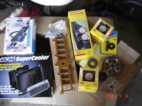 1990 Ford Bronco - A collection of automotive performance and cooling parts are laid out on a cardboard surface.