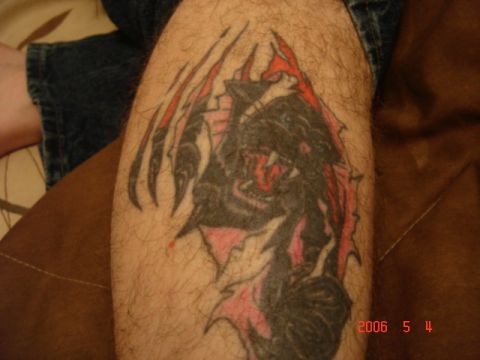 1990 Ford Bronco - A tattoo of a creature with sharp claws and teeth is visible on a person's leg.