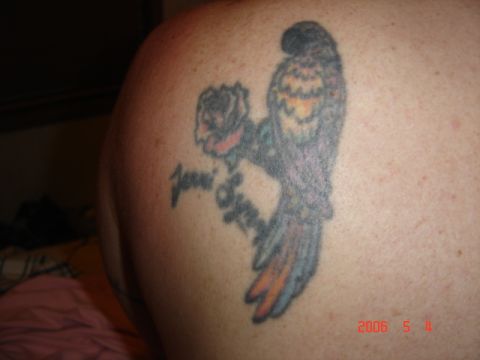 1990 Ford Bronco - A tattoo of a parrot and a rose with the name 'Joni' is visible on a person's shoulder.