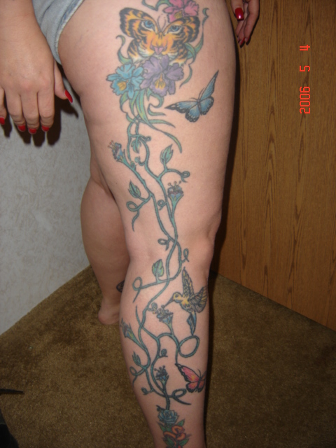 1990 Ford Bronco - A tattoo of a tiger-faced butterfly, flowers, and hummingbirds is visible on a person's leg.