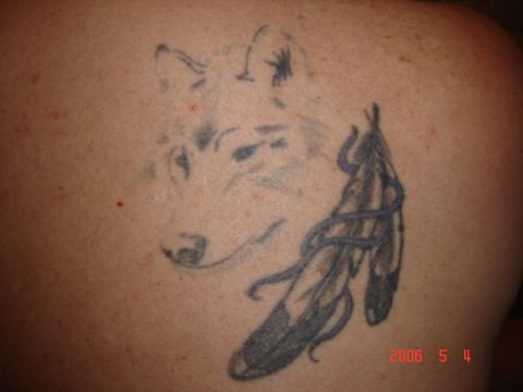1990 Ford Bronco - A tattoo of a wolf head and feathers is visible on skin, with a watermark at the bottom right.