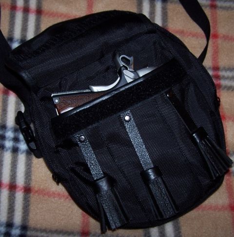 1990 Ford Bronco - A black tactical bag with a firearm peeking out from a front pocket, set against a plaid background.