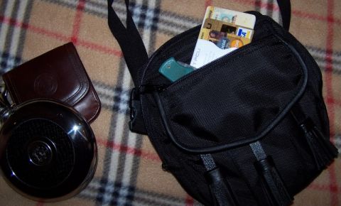 1990 Ford Bronco - A black organizer bag holds credit cards and a pocket knife, with other personal items nearby.
