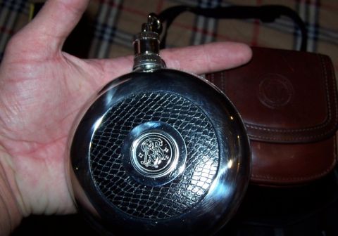 1990 Ford Bronco - A person holds a decorative metal flask and a leather pouch.