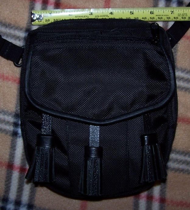 Black sporran with three tassels and a measuring tape above it