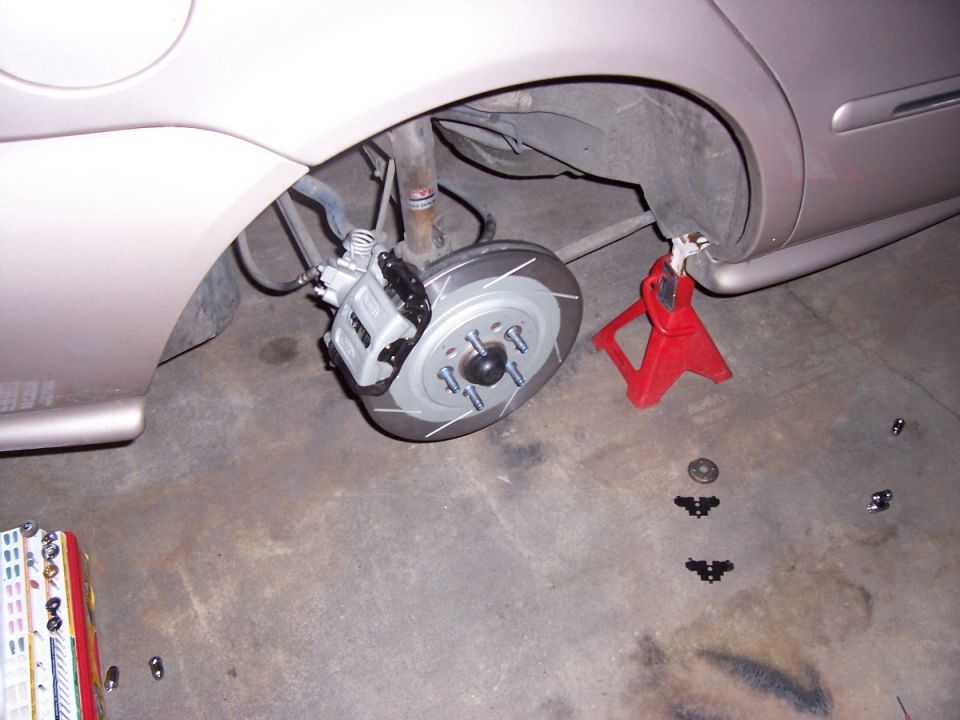 Rear brake caliper and rotor assembly with slotted rotor and silver caliper