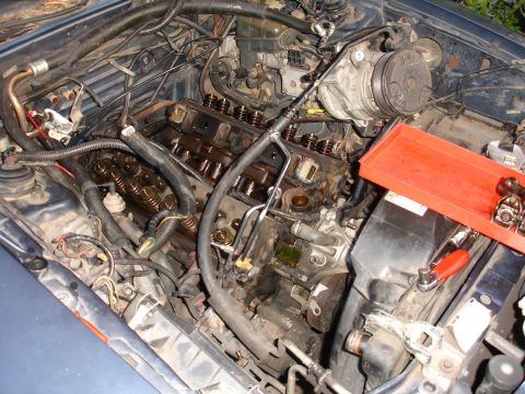 1989 Lincoln Continental - The engine's internal components are exposed, with tools and a red tray nearby.