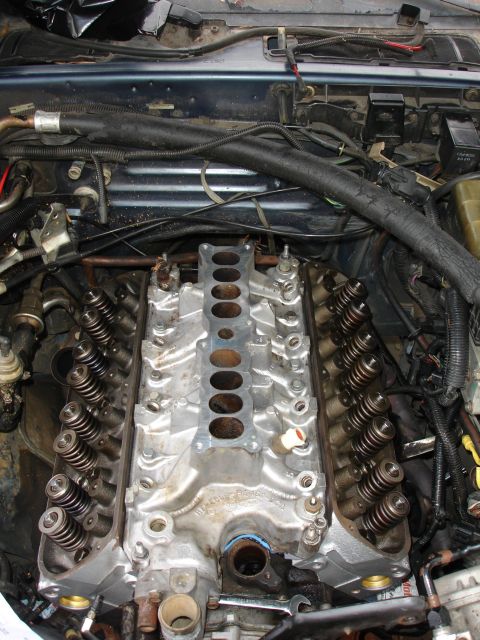 1989 Lincoln Continental - Close-up view of an engine's intake manifold and valve train components during repair.