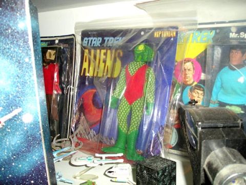 1984 Pontiac Fiero - A collection of Star Trek action figures and toys are displayed on a shelf, including vintage packaging and modern items.